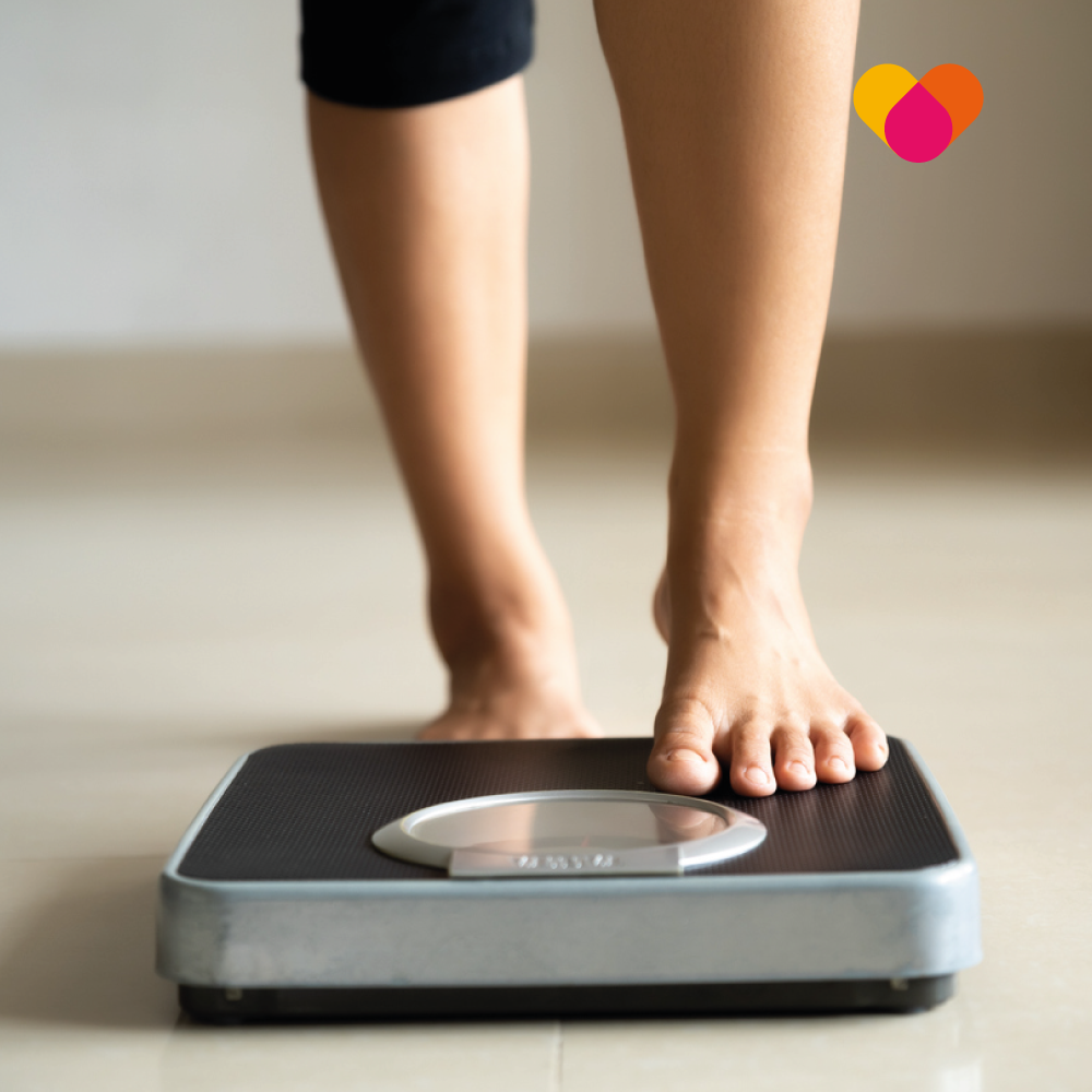 Woman stepping onto weighing scales