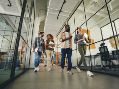 Group of people walking through the office talking