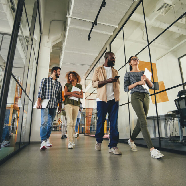 Group of people walking through the office talking