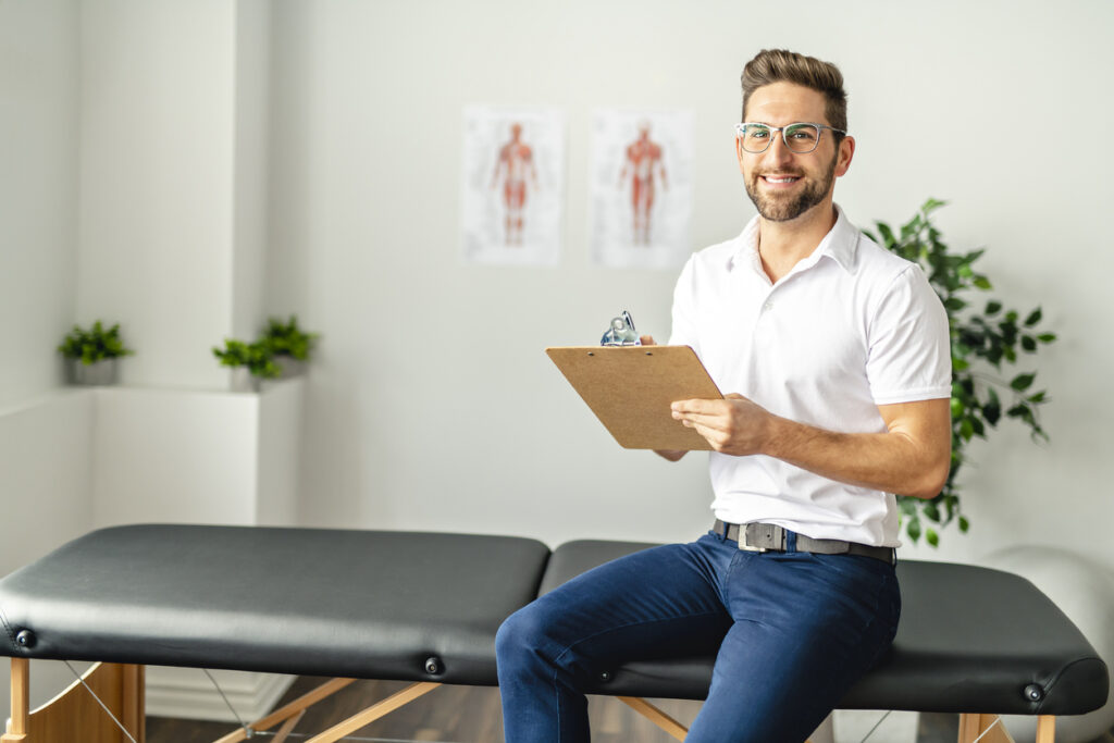 Male physio sitting on a bench