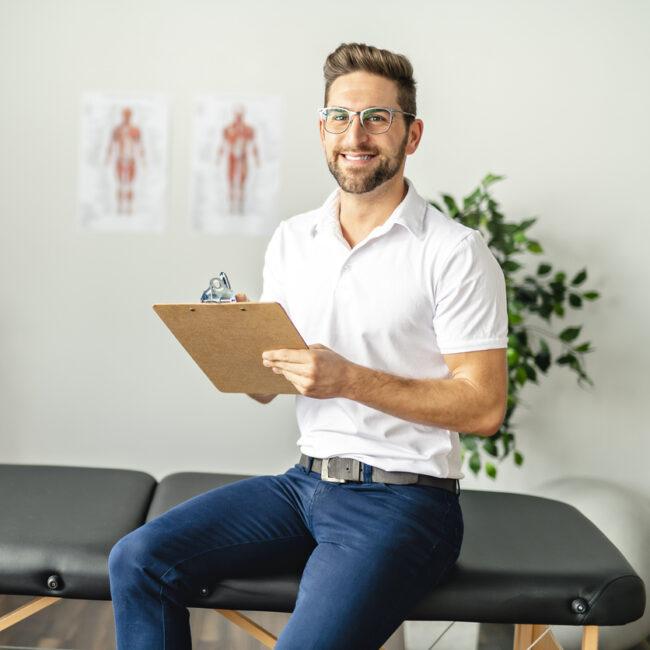 Male physio sitting on a bench